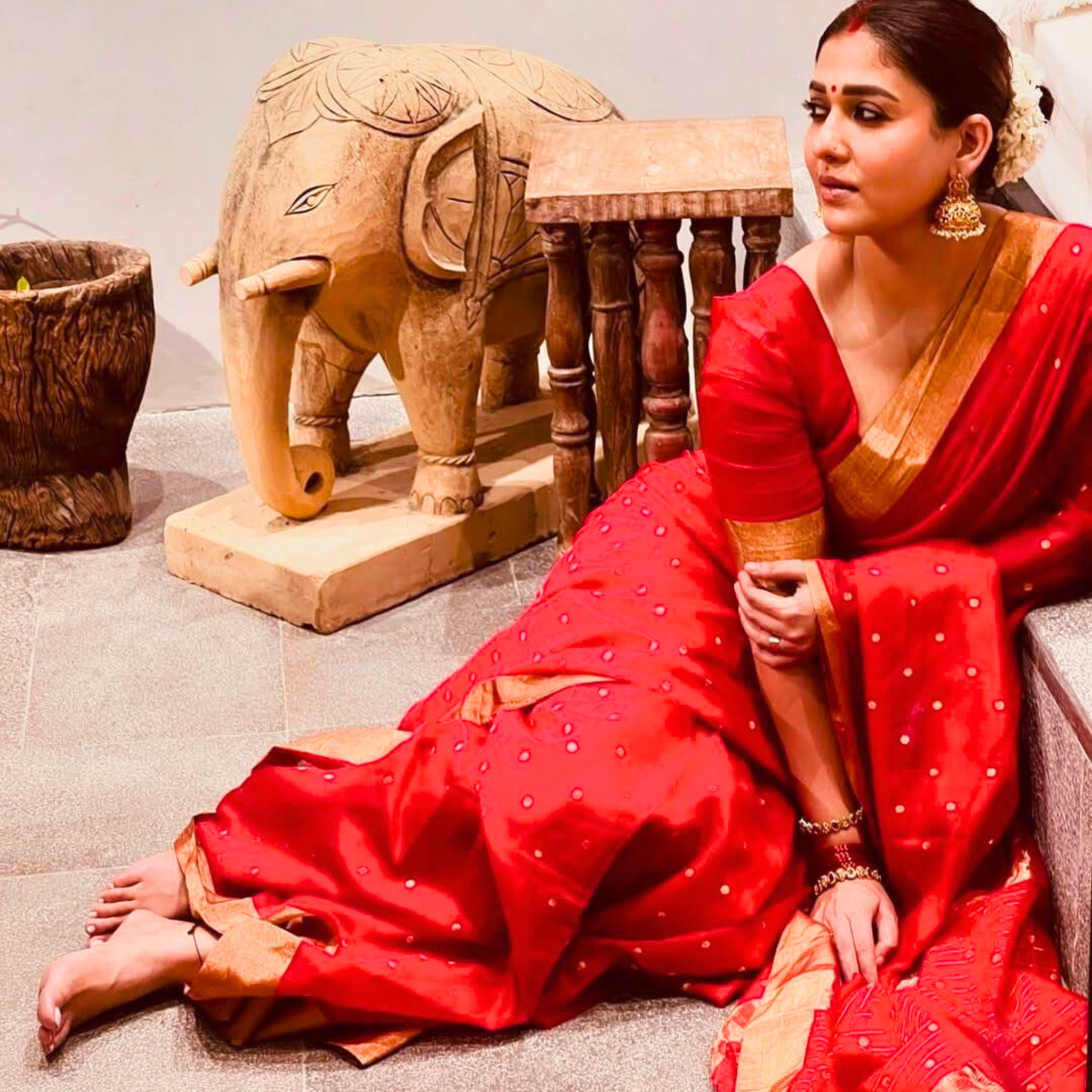 Nayanthara inspired red saree with gold polka dots and a rich gold border next to a smartphone showing the actress's look