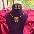 Antique gold finish temple pendant necklace with ruby kemp stones and matching jhumkas on a purple bust stand